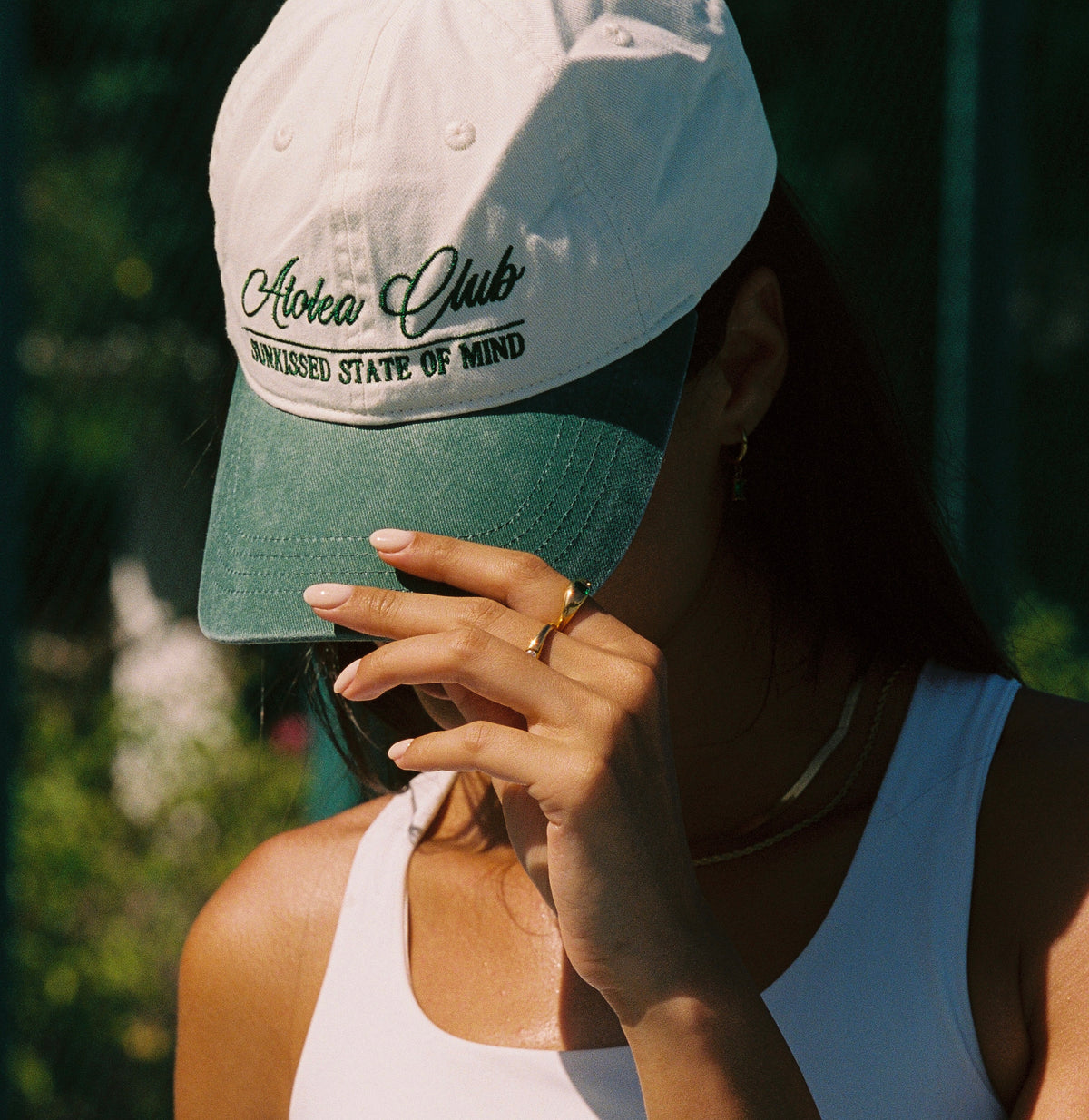 Woman wearing the Atolea cream and green embroidered baseball cap
